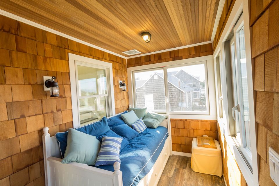 Sunroom with cedar shake interior walls and a window seat
